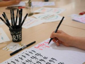Persona practicando lettering a mano durante un taller de iniciación al lettering en Madrid