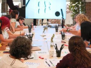 Personas aprendiendo lettering en un taller de iniciación en Madrid