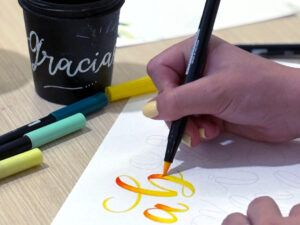 Persona practicando lettering con rotuladores de colores en un taller de lettering y color en Madrid