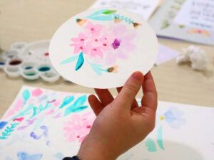 Persona mostrando una ilustración de flores pintadas con acuarela en un taller de acuarela floral en Madrid