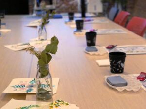 Mesa preparada para un taller de acuarela floral con materiales y pinturas de flores